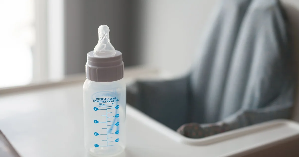 A feeding bottle on a high-chair tray