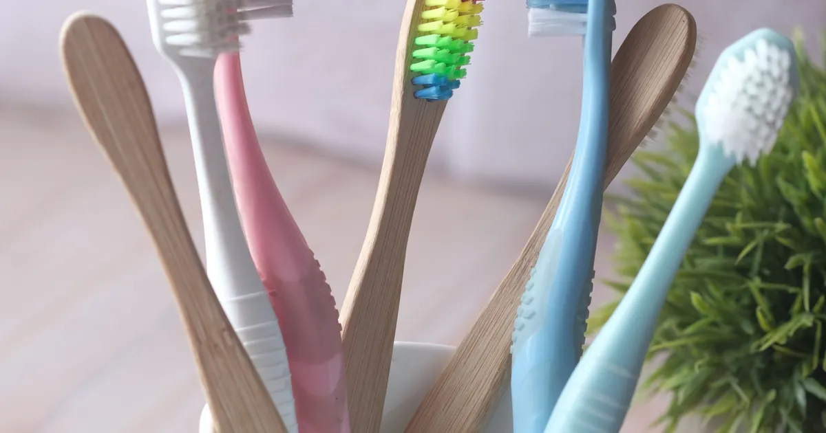 Several toothbrushes standing in a white mug