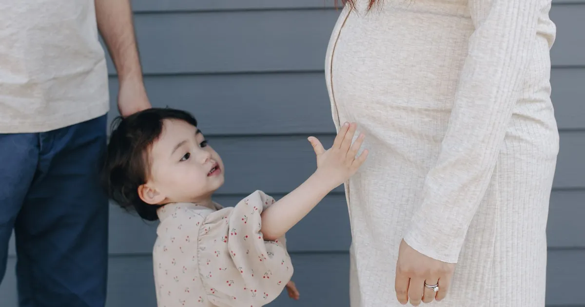 A child touching their pregnant mother’s belly