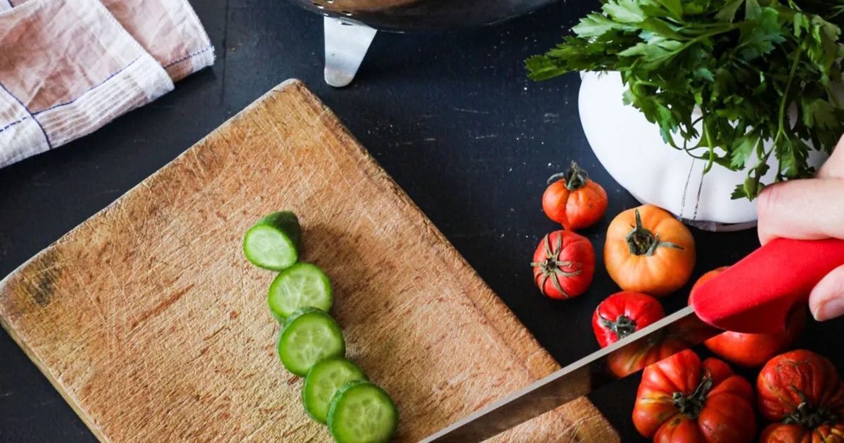 Cucumber and vegetables on a chopping board for food preparation